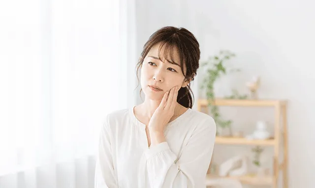 口元の痛みに悩む女性