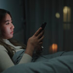 Woman using smartphone at night.