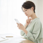A Japanese woman life scene, she is looking at her phone.